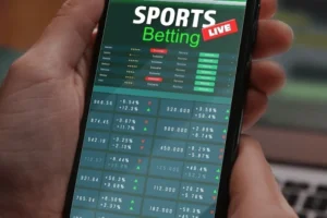 ACMA says betting firms’ failures undermine BetStop national self-exclusion system. Hand holding a smartphone displaying a sports betting app interface with live odds, match listings, and fluctuating betting data.