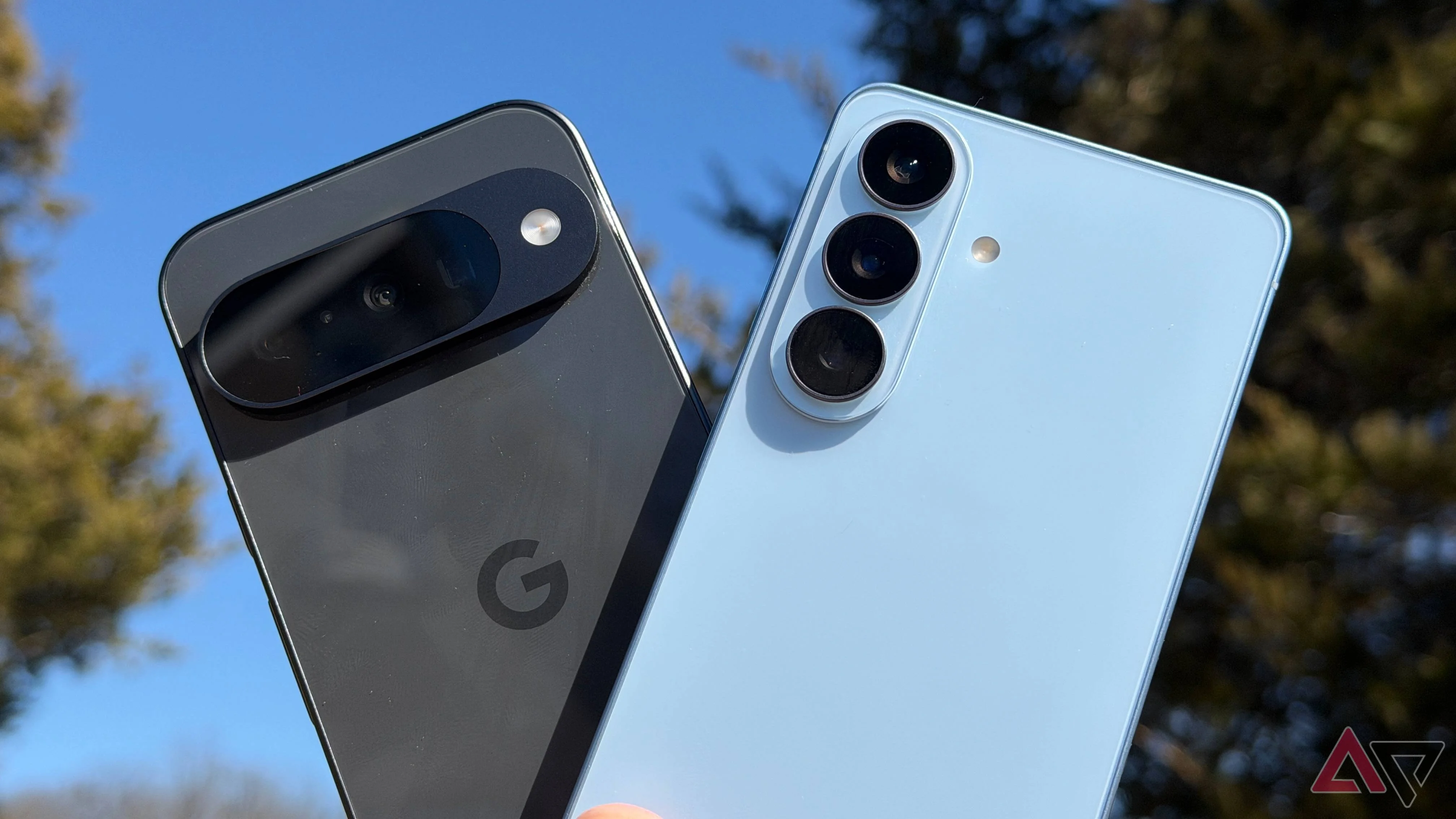 Samsung Galaxy S26 and Google Pixel 10 held up against sky