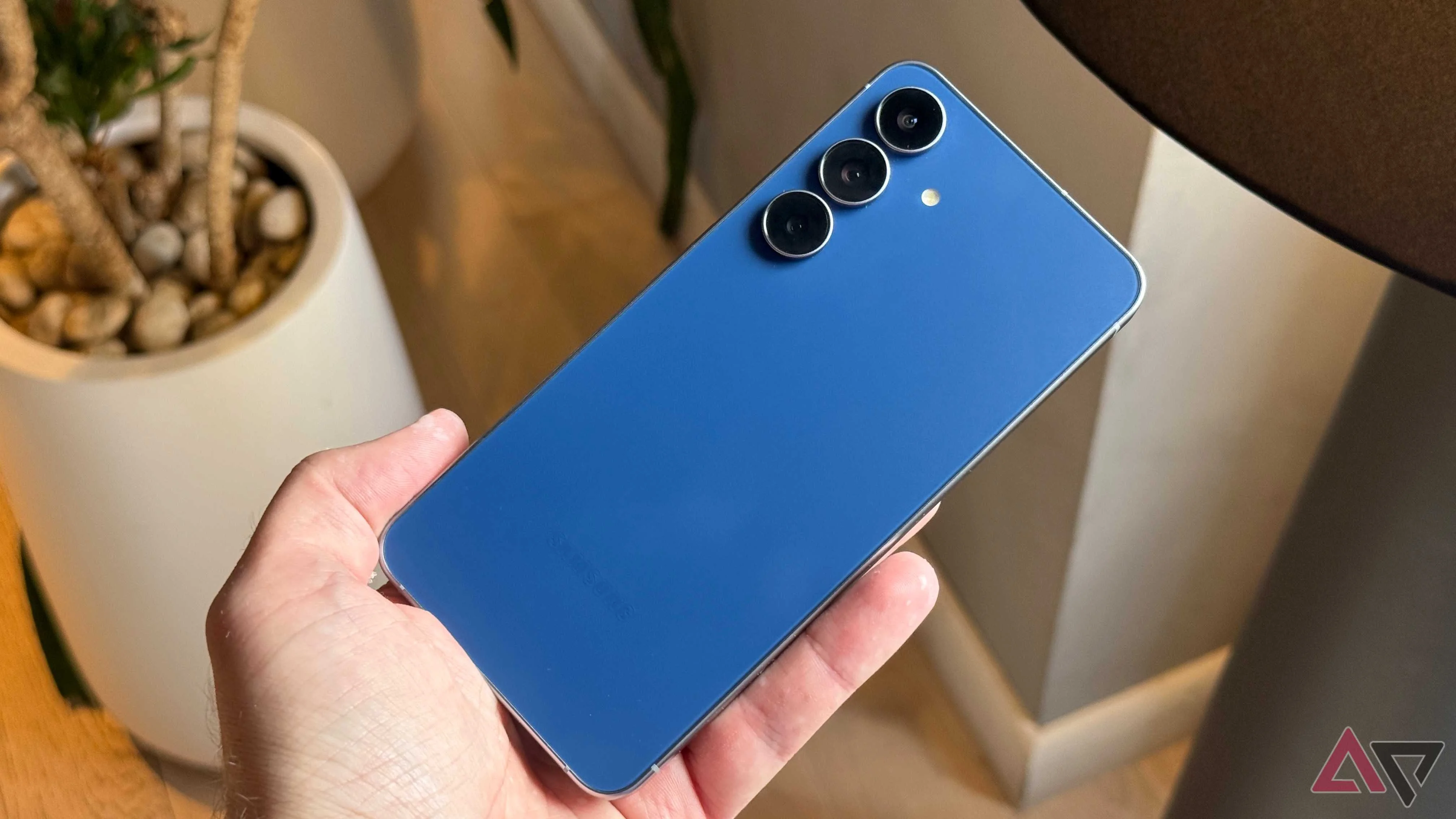 Samsung Galaxy S25 FE held against a lamp